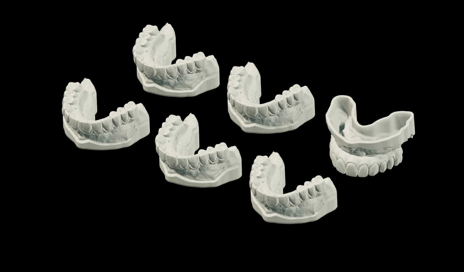 Ivory dental print models arranged in staggered rows, rendered from an exported model.